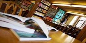 Open books on a wooden table in a library.